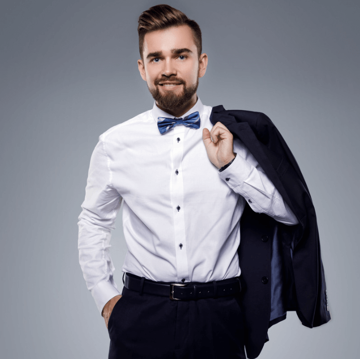 Mann in eleganter Kleidung mit Schlips, hält Anzugjacke und lächelt