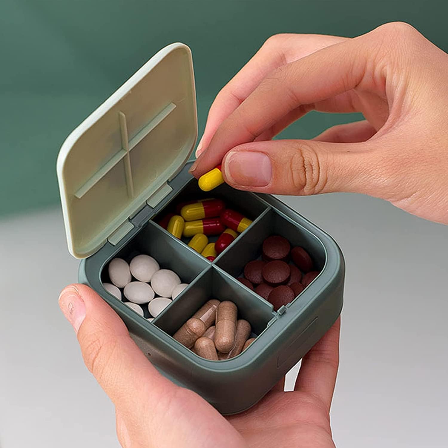 Medivita MiniMed – Kompakte Pillenbox mit geöffnetem Deckel und verschiedenen Pillen im Inneren.