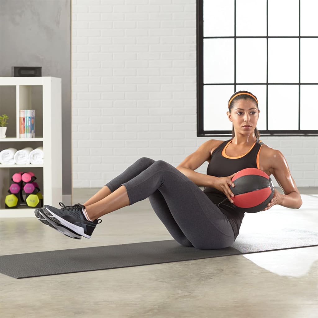 Frau trainiert mit dem Medivita CoreBall für Kraft und Stabilität auf einer Fitnessmatte.