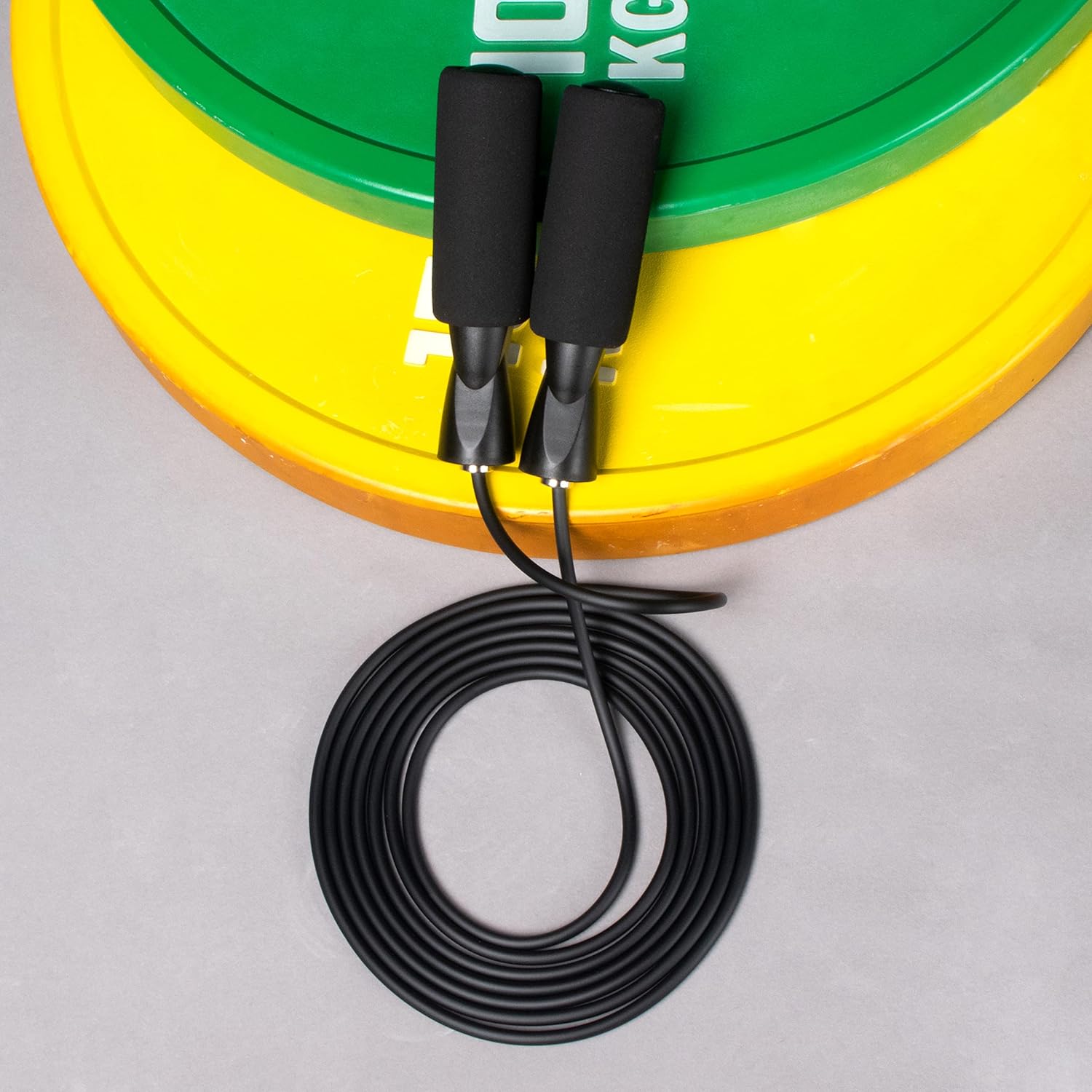 Medivita SpeedRope auf einer Gewichtsscheibe, vielseitiges Springseil für Cardio und Fettverbrennung.